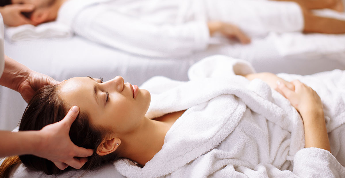 A woman laying on her stomach in a white robe.