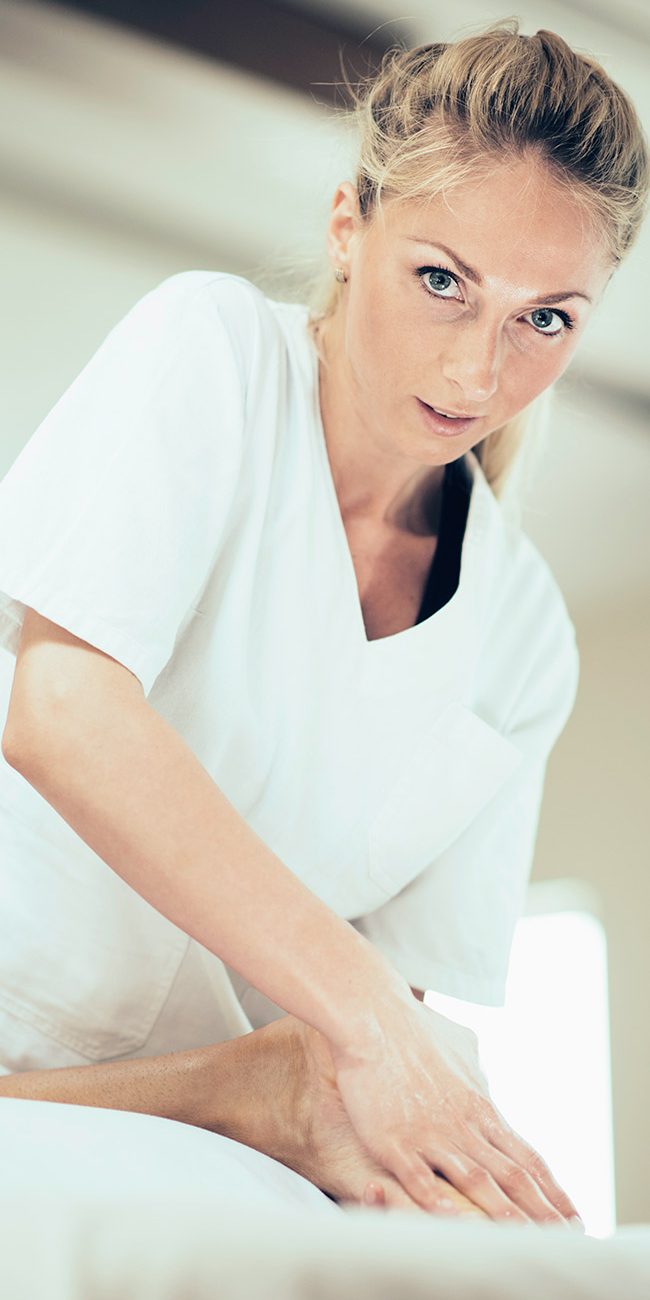 A woman in white shirt holding something on top of table.