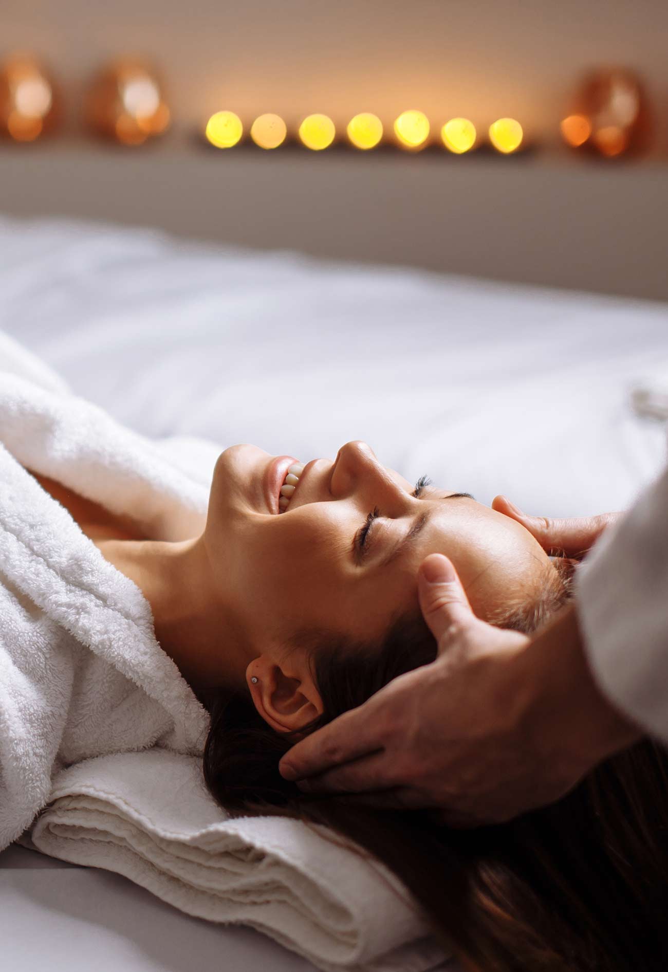 A person laying on top of a bed with their eyes closed.
