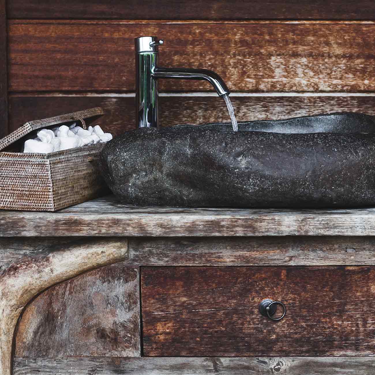 A sink with a wooden counter and wood walls
