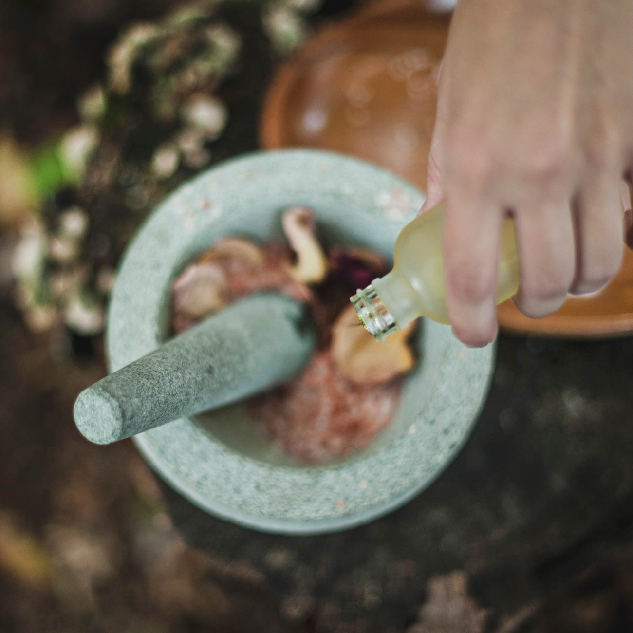 A person is using a mortar and pestle to grind food.