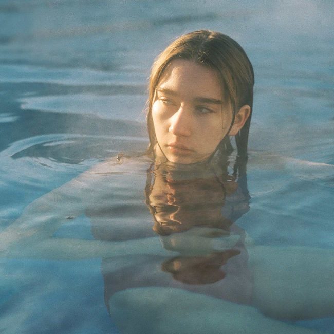 A woman in the water with her head above the surface.