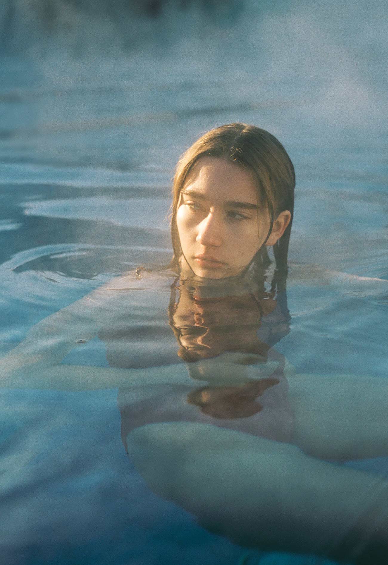 A woman in the water with her head above the surface.