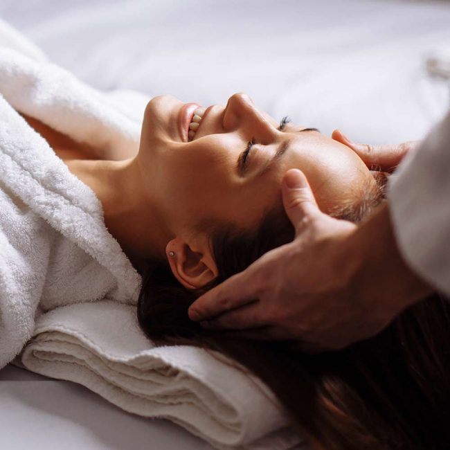 A person getting their head washed by a masseur.