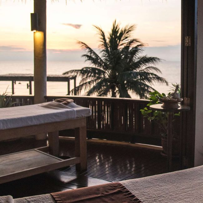 A view of the ocean from a bedroom at sunset.