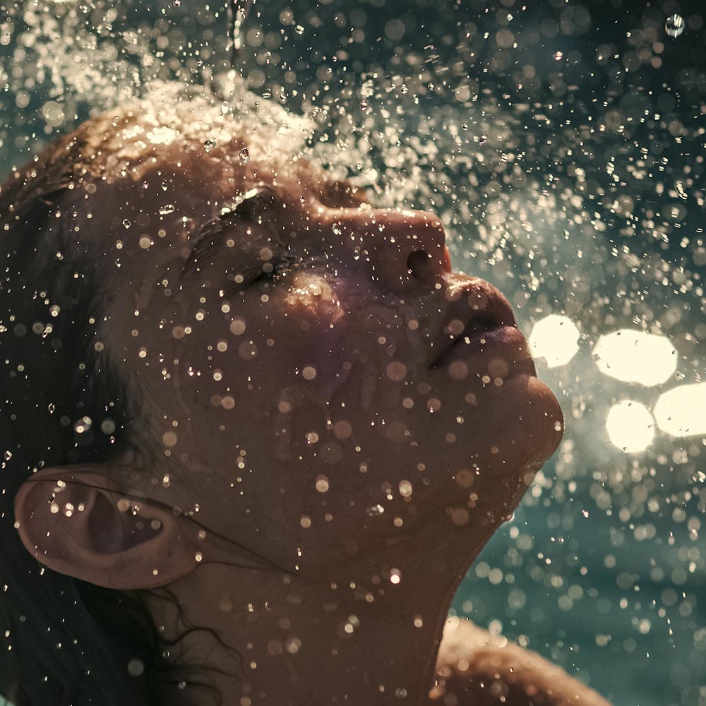 A person is taking a shower in the water.