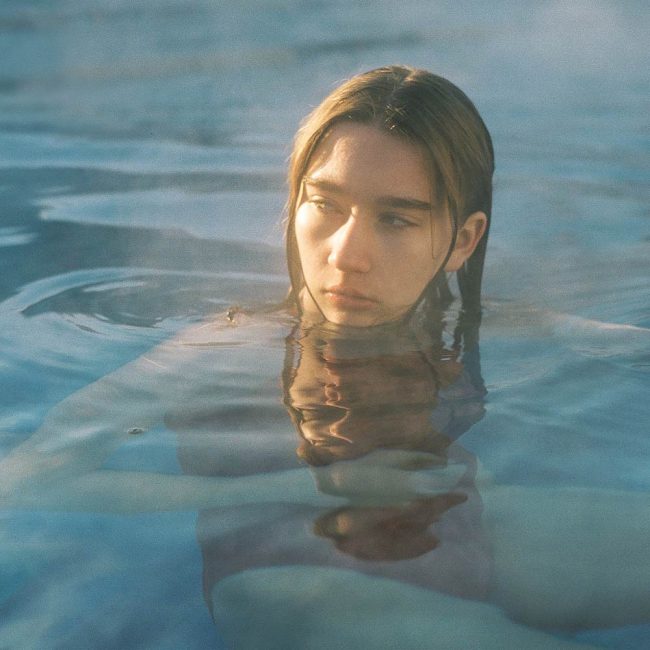 A woman in the water with her head above the surface.