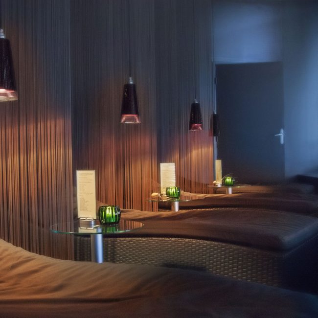A room with several beds and lamps in it