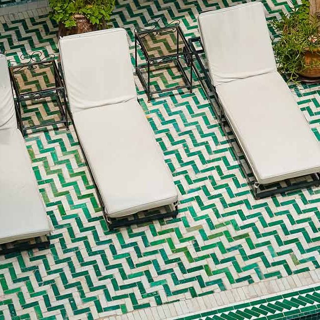A view of some chairs and a pool.