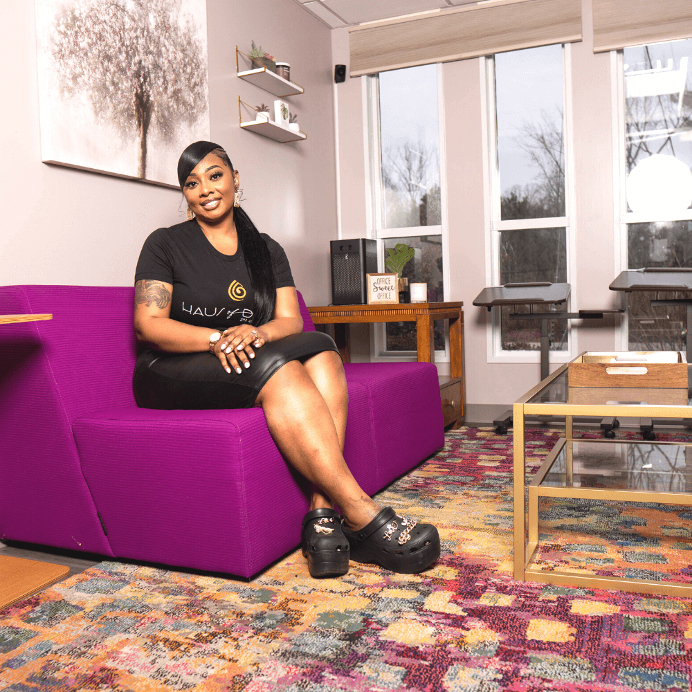A woman sitting on top of a purple couch.