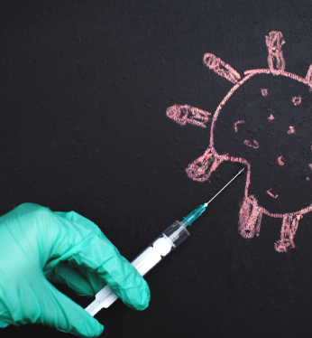 A person with green gloves is drawing an image on the wall.