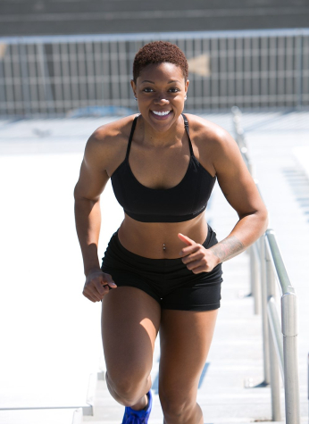 A woman in black top and shorts running.