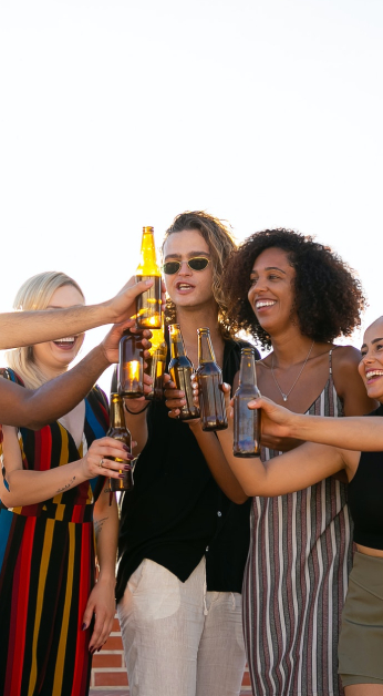 A group of people holding beers and drinking.